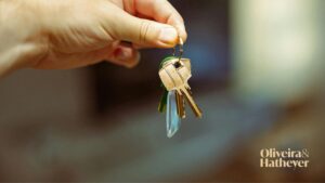 Mão entregando chaves, simbolizando locação, compra ou conclusão de uma negociação imobiliária.